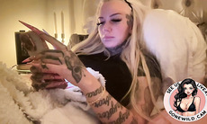 Inked Blonde Bombshell Holding Toys in Bed